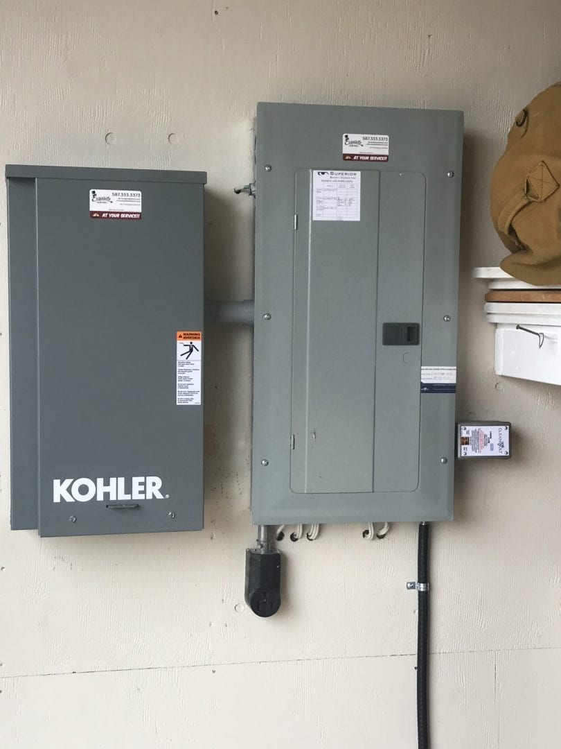 Kohler Electrical Panel installed with generator at a rural Alberta Residence image of a kohler generator panel and an electrical panel with a surge protector