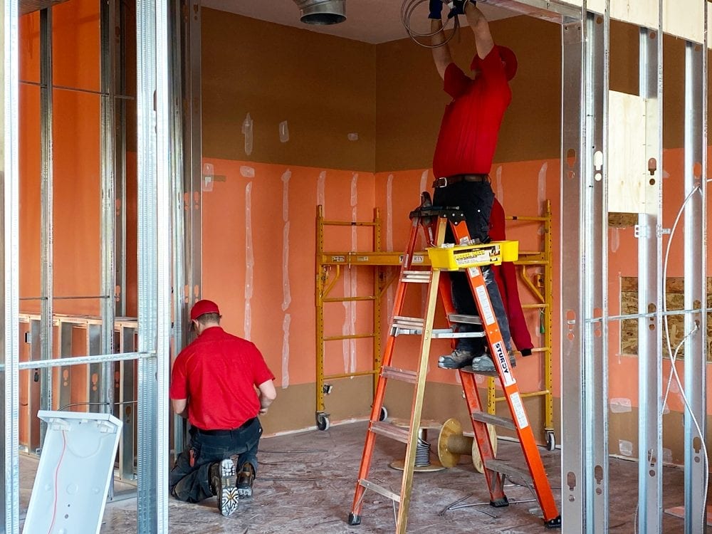 Exquisite-Electricl-Commericial-Renovation-Repair-Electrical-Contractor image of Exquisite Electric Electrican Dustin and electrical apprentice working on Okotoks business renovation