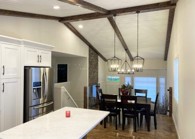 image of Pot lights installed in a shiplap ceiling with artificial beams and pendant lighting above a kitchen table
