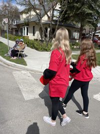 image of 2 girls from Exquisite Electric handing out candy at the 2022 High River Little Britches Parade
