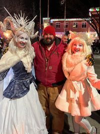 image of Bryan from Exquisite Electric with Snow Queen performers in costume at the 2022 Light Up Okotoks